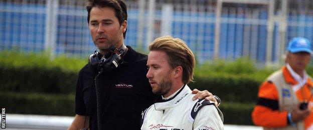 Nick Heidfeld walks back to the pits