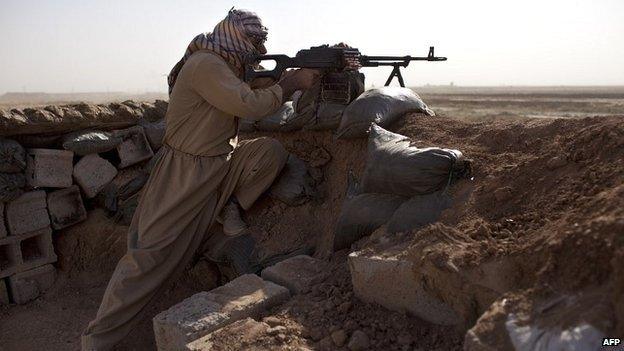 A Kurdish fighter fires towards Islamic States militants during clashes 50km east of Tikrit, Iraq - 11 September 2014