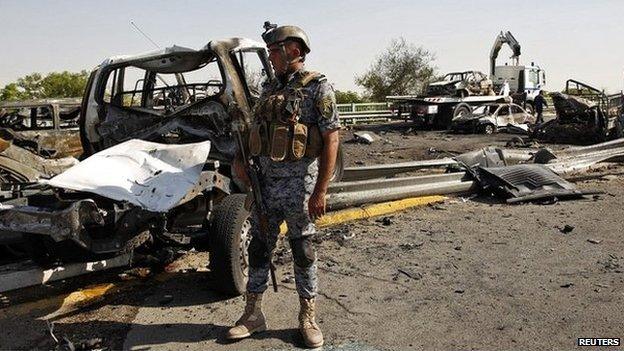 A member of the Iraqi security forces inspects the site of an explosion in a Shia neighbourhood of Baghdad - 10 September 2014