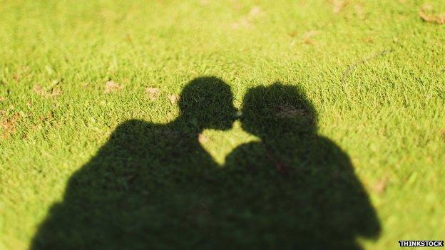 shadow of people kissing on grass