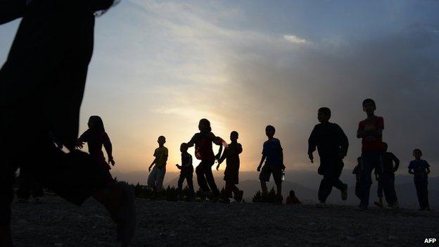 Afghan children run to see the largest Afghan flag after an inauguration ceremony at Wazir Akbar Khan hill in Kabul on September 10, 2014.