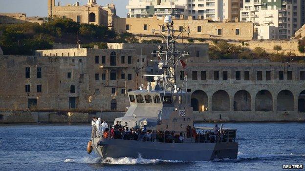 An Armed Forces of Malta (AFM) patrol boat carrying rescued migrants approaches the AFM"s Maritime Squadron base at Haywharf in Valletta"s Marsamxett Harbour, August 28