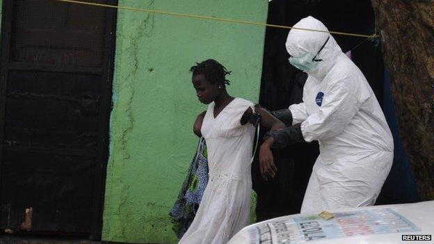 A health worker brings a woman suspected of having contracted the Ebola virus to an ambulance in Monrovia, Liberia (15 September)