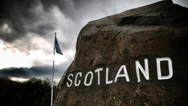 Scotland border sign with flag in background