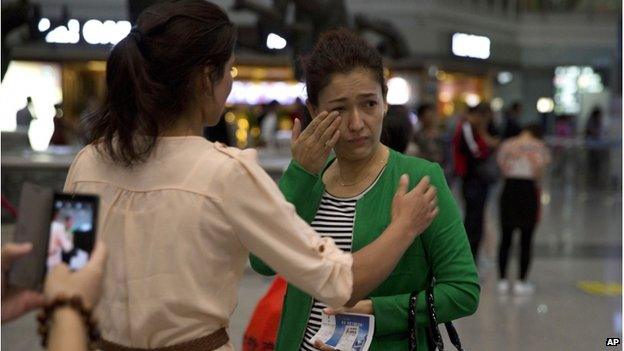 Guzulnur, wife of detained Uighur scholar Ilham Tohti cries as she bids farewell to friends before leaving on a flight for Urumqi at the capital airport in Beijing, China, Monday, 15 Sept 2014