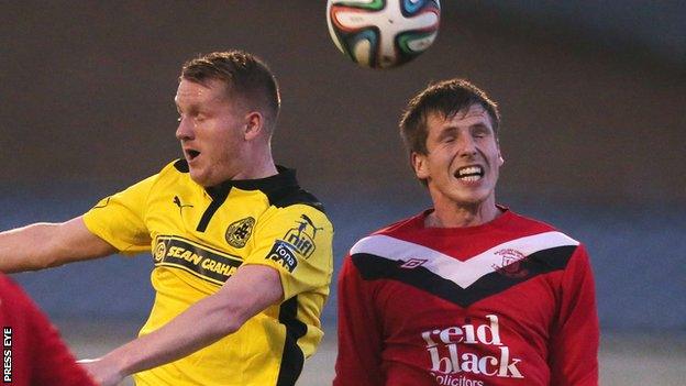 Cliftonville midfielder Martin Murray contests a high ball with Ballyclare's Randal Reid