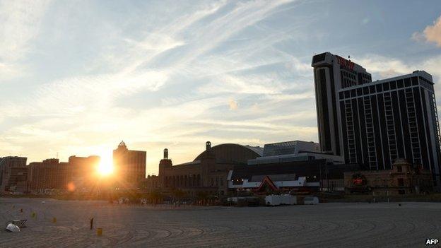 The sun sets behind the Trump Plaza Casino(R) in Atlantic City, New Jersey 15 September 2014