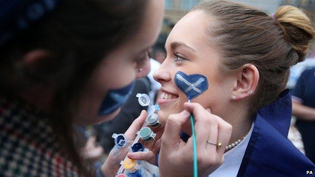 Girl's face being painted with Saltire symbol during Glasgow rally