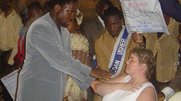 TB Joshua attending to a follower