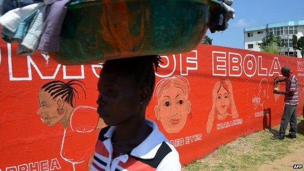 Street artist Stephen Doe paints on 8 September 2014 a mural to inform people about the symptoms of the deadly Ebola virus in Monrovia, Liberia