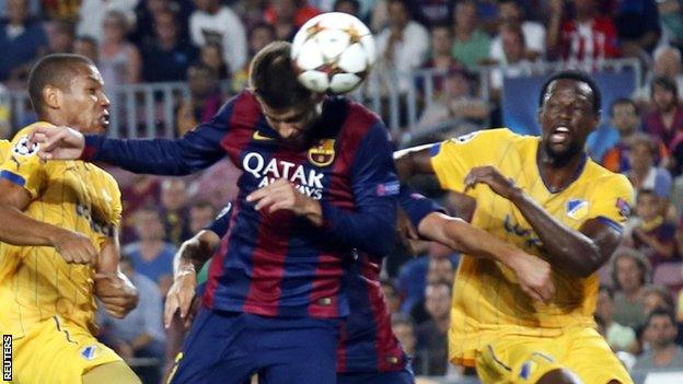 Barcelona defender Gerard Pique heads his team ahead against Apoel Nicosia in the Champions League