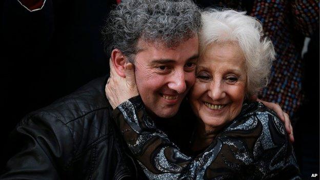 In this 8 August 2014 photo, Estela de Carlotto, right, and her grandson Guido embrace as they pose for cameras at a news conference in Buenos Aires, Argentina.