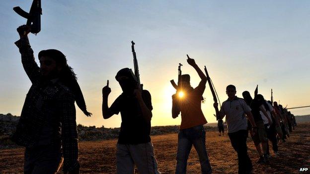 Members of Jihadist group Hamza Abdualmuttalib (in silhouette) train near Aleppo on 19 July 2012.