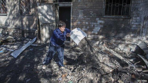 A woman clears up after shelling in Donetsk (17 Sept)