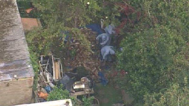 Forensics officers in the garden of the home of Arnis Zalkalns