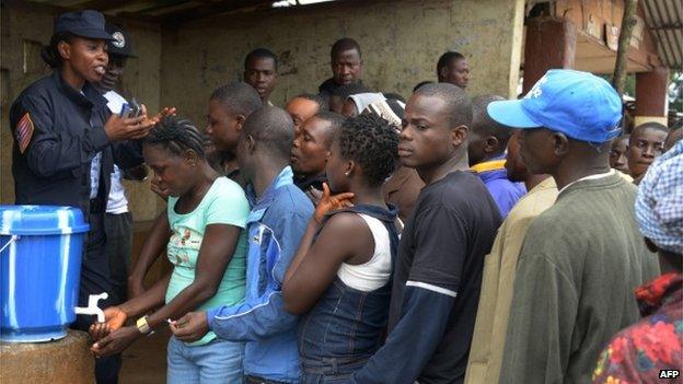 Liberians wait to clean their hands