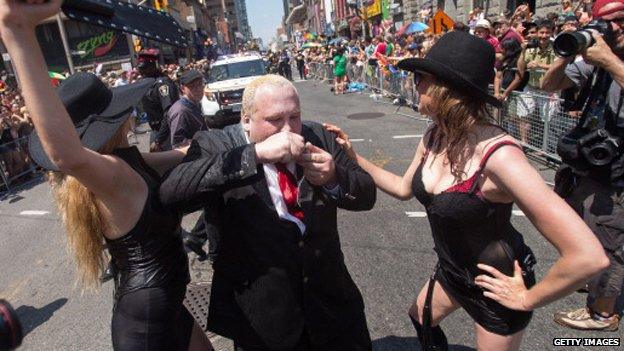 A Rob Ford lookalike pretends to smoke a crack pipe at World Pride Day in Toronto