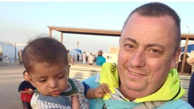 Alan Henning holding a child in Syria