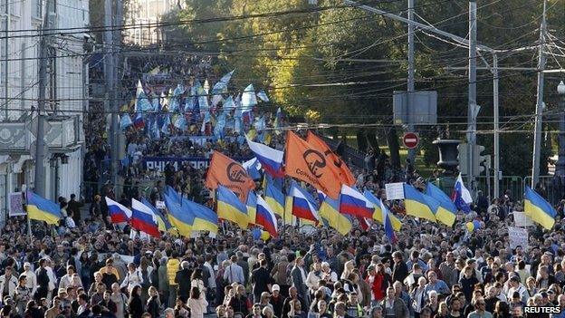 People walk with banners and flags during an anti-war rally in Moscow - 21 September 2014