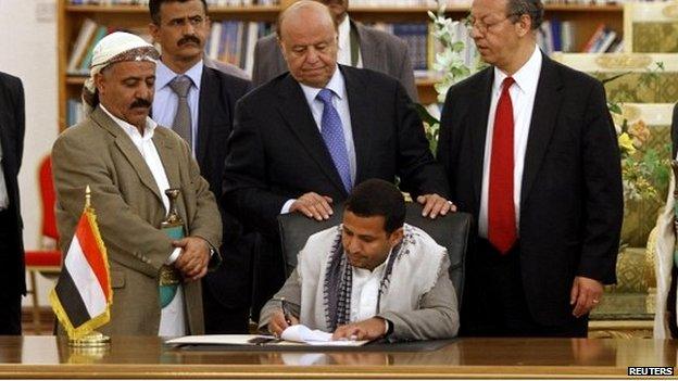 Hussein al-Ezzi, the Houthi's head of political relations, signs the agreement at a ceremony in Sanaa - 21 September 2014