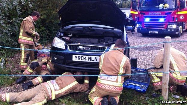 Firefighters working on car