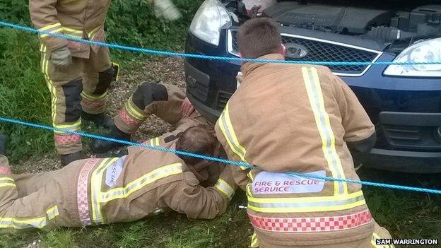 Firefighters working on car