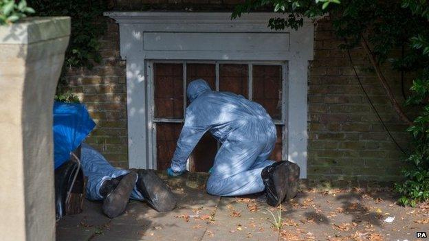 Officers searching the home of Arnis Zalkalns