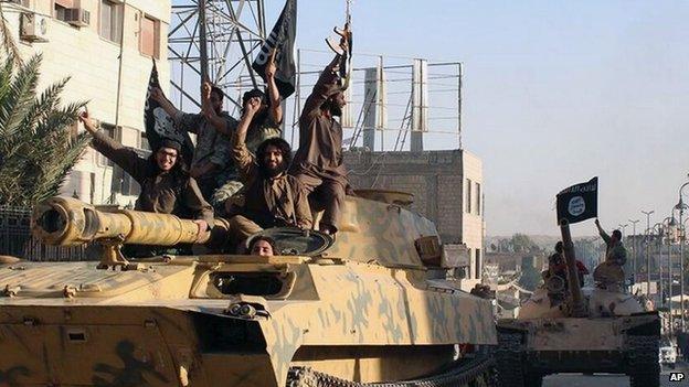 Fighters from the al-Qaida-linked Islamic State group parade in Raqqa, Syria, on 30 June 2014