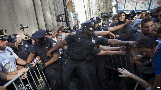 Protestors and police wrestle near a barricade on the corner of Wall Street and Broadway during a march demanding action on climate change and corporate greed on Monday (22 September 2014)