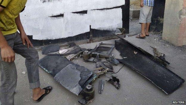 A man inspects the remains of what Islamist State militants say was a US drone that crashed in Raqqa - 23 September 2014