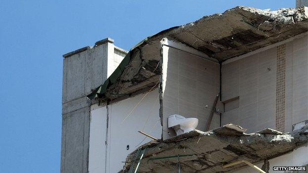 A toilet still stands on 17 October 2013 on what is left of the top floor of a building that collapsed on 12 October 12 in Medellin