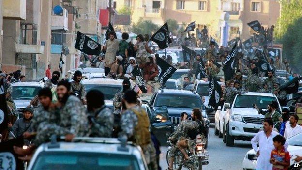 Islamic State fighters parade through the Syrian city of Raqqa on 30 June