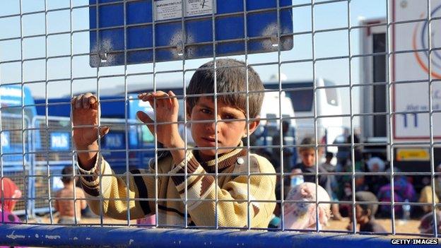 A young Syrian Kurdish refugee enters Turkey at the Yumurtalik crossing gate near Suruc on 23 September 2014 in Turkey.