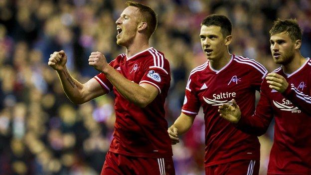 Adam Rooney (left) celebrates his first and Aberdeen's second against livingston.