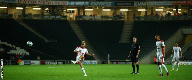 Ben Reeves of MK Dons takes a freekick with empty stands behind