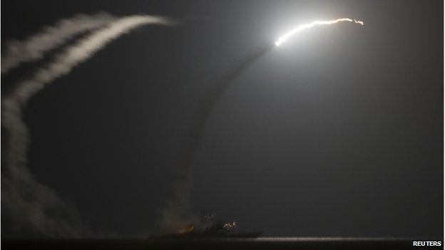 A cruise missile being launched from a warship at night