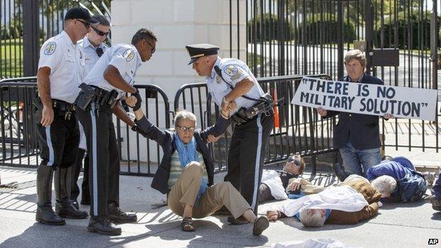 Anti-war activists, angered by military strikes in Syria, block the northwest gate of the White House on Pennsylvania Avenue in Washington, 23 September 2014