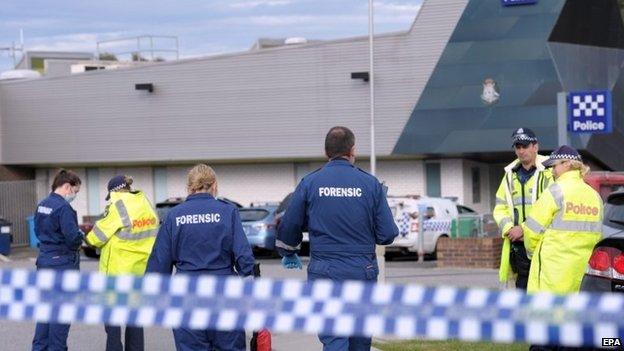 Police and forensic officers investigate the scene of a fatal shooting of an 18-year-old man at Endeavour Hills Police Station in Melbourne, Victoria, Australia, on 24 September 2014