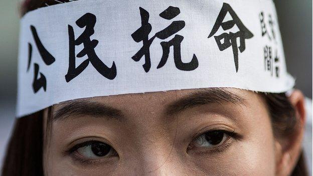 A student wears a headband with Chinese characters that read ''Civil Disobedience'' during the rally outside Hong Kong government complex on September 23,