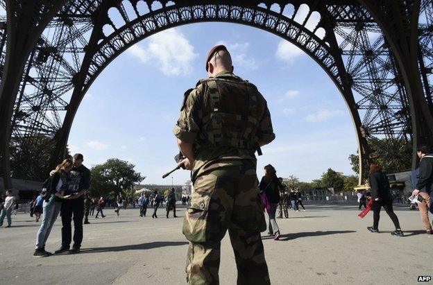 A French paratrooper patrols near the Eiffel Tower in Paris, 23 September