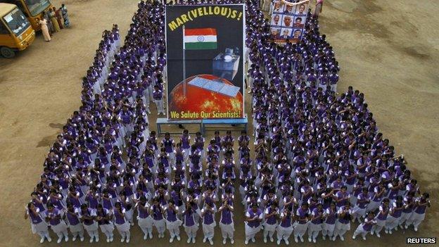 Students pose in a group with banners featuring Mars and Indian Space Research Organization (ISRO) scientists (R) as they celebrate India"s Mars orbiter successfully entering the red planet"s orbit, at a school in the southern Indian city of Chennai September 24, 2014.