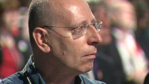 A man watches Harry Smith's speech