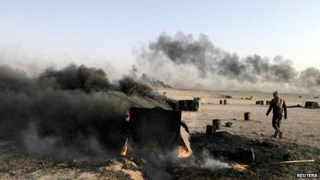 File photo: A man walks at a makeshift oil refinery site in al-Mansoura village in Raqqa's countryside, 5 May 2013