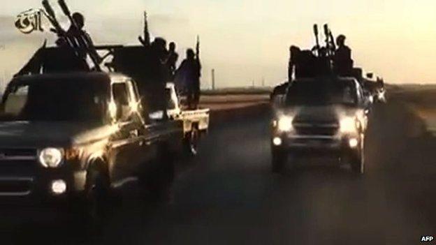 An image grab taken from a video released by Islamic State group's official Al-Raqqa site via YouTube on 23 September 2014, allegedly shows Islamic State (IS) group recruits riding in armed trucks in an unknown location