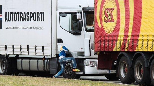 An illegal migrant steps into a truck going to the UK on 10 September 2014 in the French port of Calais