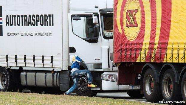 An illegal migrant steps into a truck going to the UK on 10 September 2014 in the French port of Calais