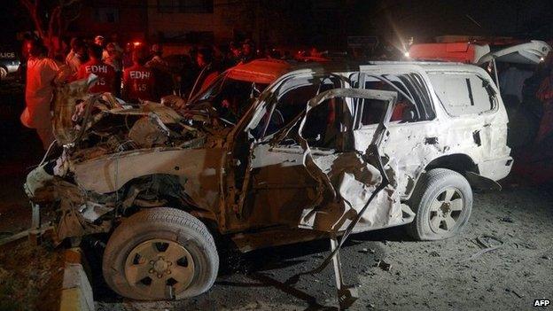 A wrecked car sits at the site of a bomb attack targeting a senior police officer in Karachi on September 25, 2014