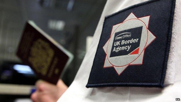 UK Border Agency officer checking a passport at London's Gatwick Airport on 23 November 2009 (file)