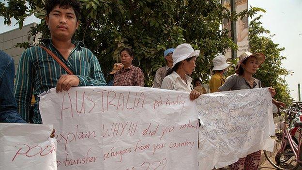 Protesters holding banners gather outside the Australian Embassy ahead of the signing of a refugee deal between Australia and Cambodia