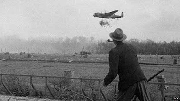 Man watching Lancaster dropping supplies